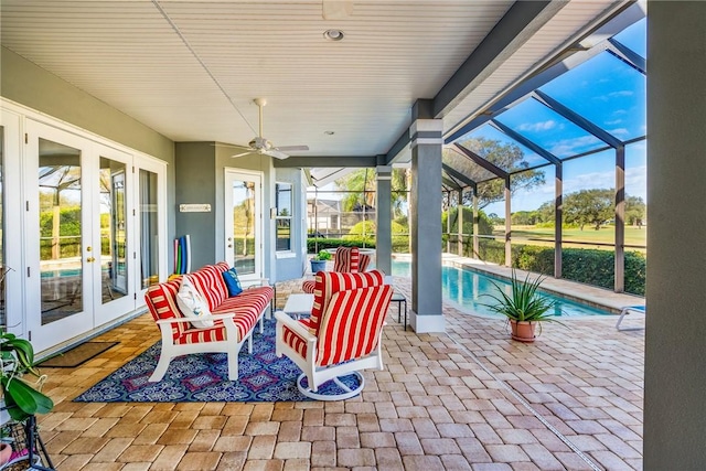 view of patio featuring ceiling fan, an outdoor living space, glass enclosure, and french doors