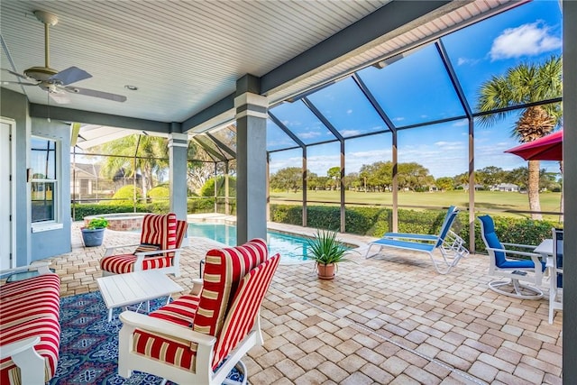 view of patio featuring ceiling fan and glass enclosure