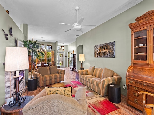 living room featuring ceiling fan, wood-type flooring, and a textured ceiling