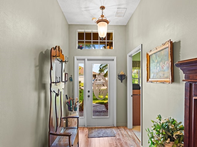 entryway with light wood-type flooring and a textured ceiling