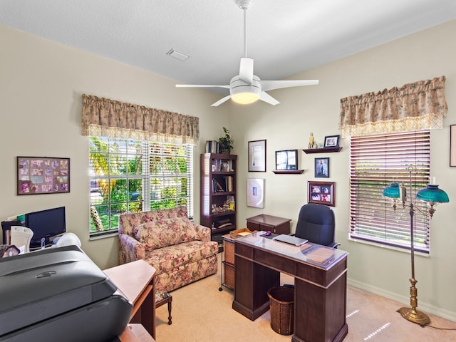 home office featuring ceiling fan, a textured ceiling, light carpet, and a healthy amount of sunlight