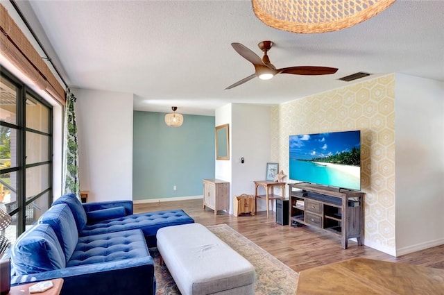 living room featuring hardwood / wood-style floors, a textured ceiling, and ceiling fan