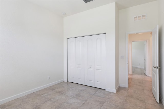 unfurnished bedroom with light tile patterned floors and a closet