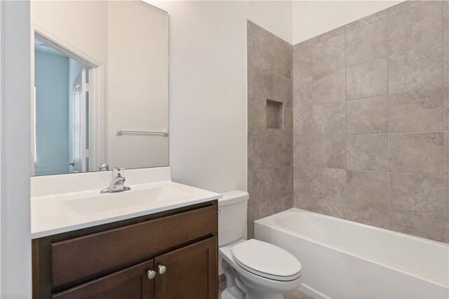 full bathroom featuring toilet, vanity, and tiled shower / bath