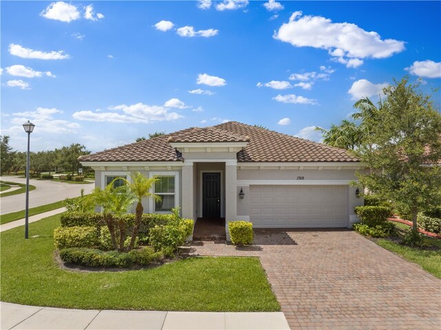 mediterranean / spanish-style home with a front lawn and a garage