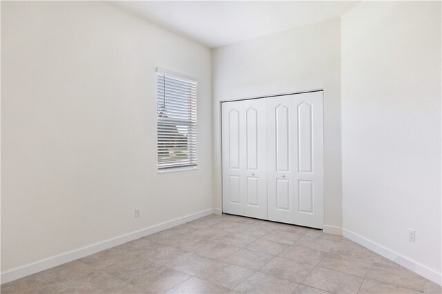 unfurnished bedroom with light tile patterned flooring and a closet