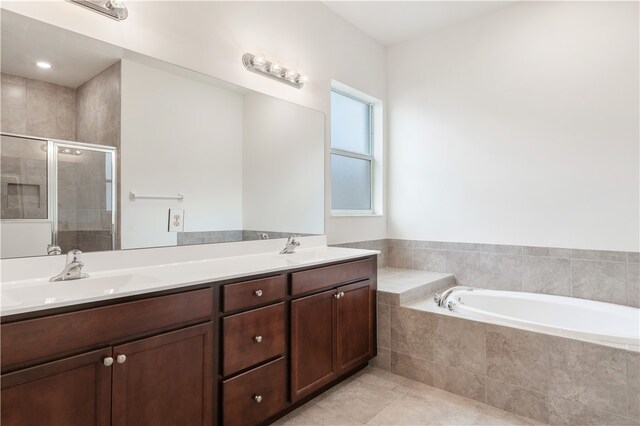 bathroom featuring plus walk in shower, vanity, and tile patterned flooring