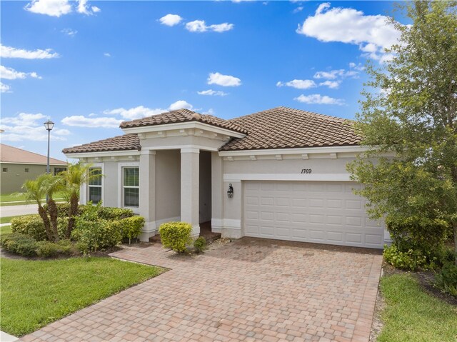 mediterranean / spanish house with a garage and a front lawn