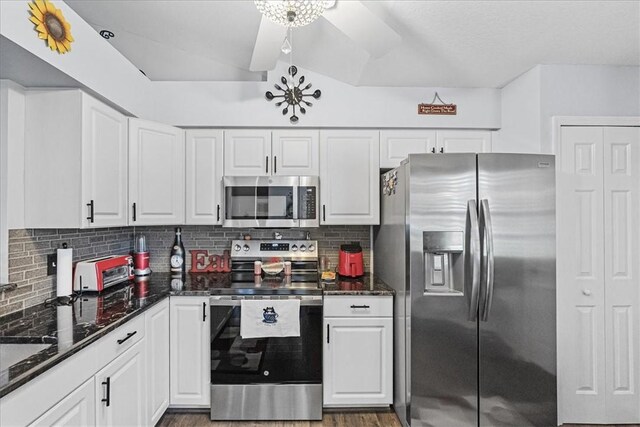 kitchen with ceiling fan, stainless steel appliances, tasteful backsplash, dark stone counters, and white cabinets