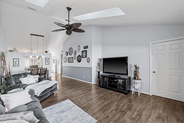 living room with ceiling fan, dark hardwood / wood-style flooring, and lofted ceiling with skylight