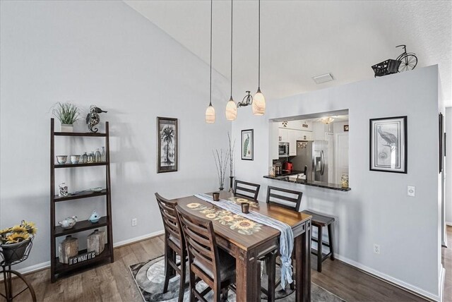 dining area featuring dark hardwood / wood-style floors and lofted ceiling