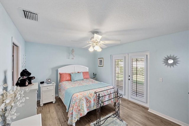 bedroom featuring hardwood / wood-style floors, ceiling fan, access to outside, and french doors