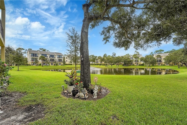 surrounding community with a lawn and a water view