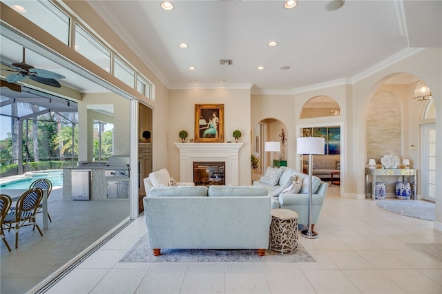 living room featuring ceiling fan, light tile patterned floors, and crown molding