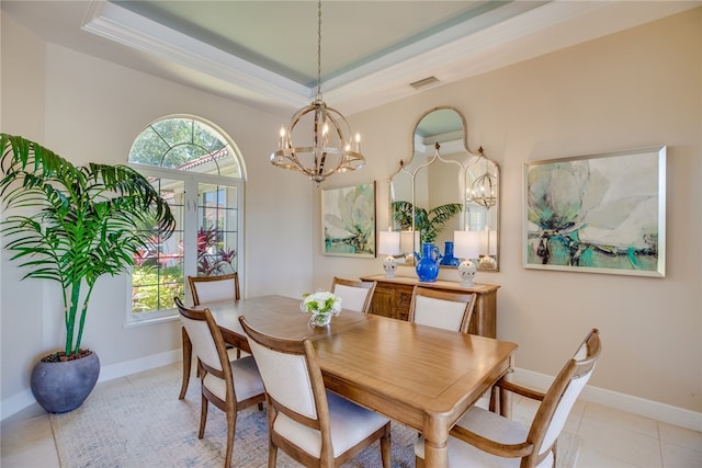 dining space featuring plenty of natural light, light tile patterned floors, an inviting chandelier, and a tray ceiling