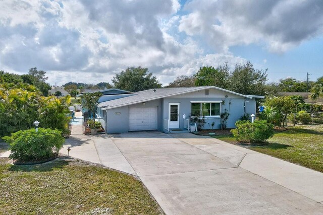 single story home with a garage and a front lawn