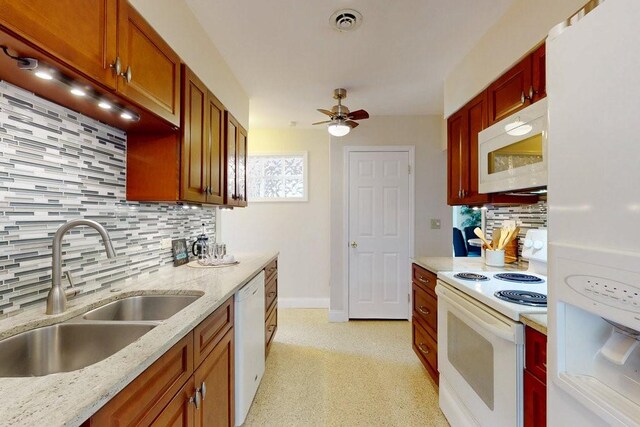 kitchen with sink, decorative backsplash, ceiling fan, light stone countertops, and white appliances