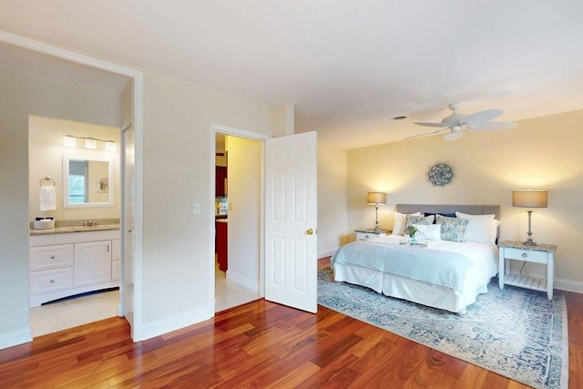 bedroom with ensuite bath, wood-type flooring, and ceiling fan