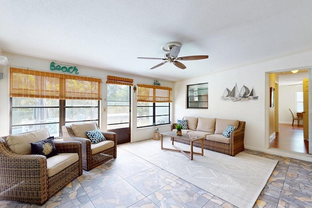 living room with ceiling fan and a textured ceiling