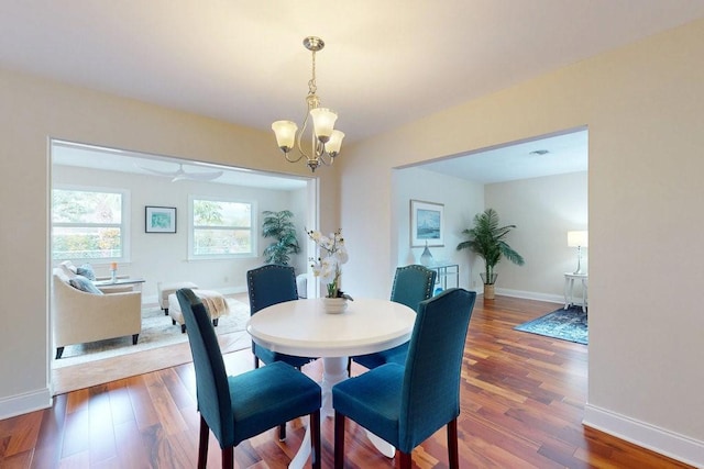 dining space with wood-type flooring and a notable chandelier