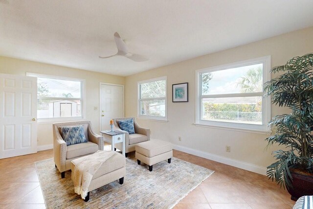 living area with light tile patterned floors and ceiling fan