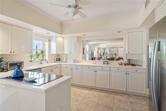 1250 W Southwinds Blvd Unit 310, Vero Beach, FL 32963 - kitchen with stainless steel fridge, light countertops, crown molding, a ceiling fan, and white cabinets