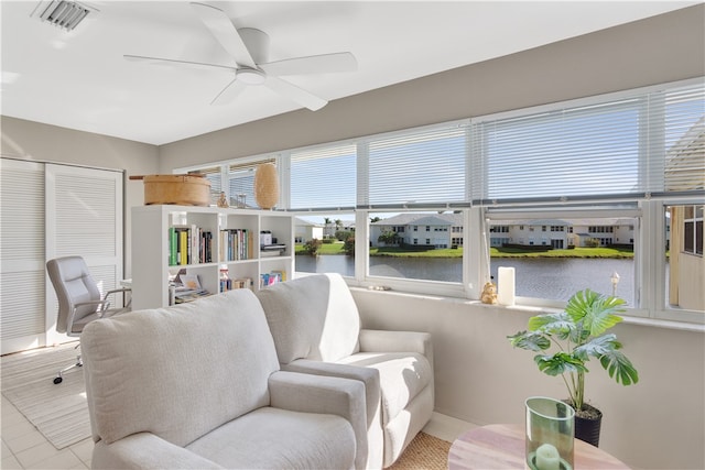 interior space featuring ceiling fan, a water view, and light tile patterned floors