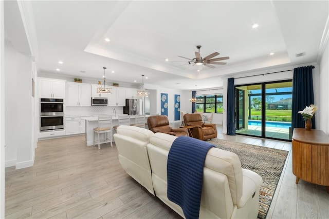 6354 Arcadia Sq, Vero Beach, FL 32966 - living room featuring a raised ceiling, a ceiling fan, light wood-type flooring, recessed lighting, and baseboards
