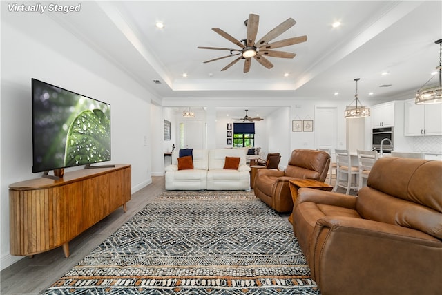 6354 Arcadia Sq, Vero Beach, FL 32966 - living room with wood finished floors, ceiling fan, a tray ceiling, a chandelier, and recessed lighting