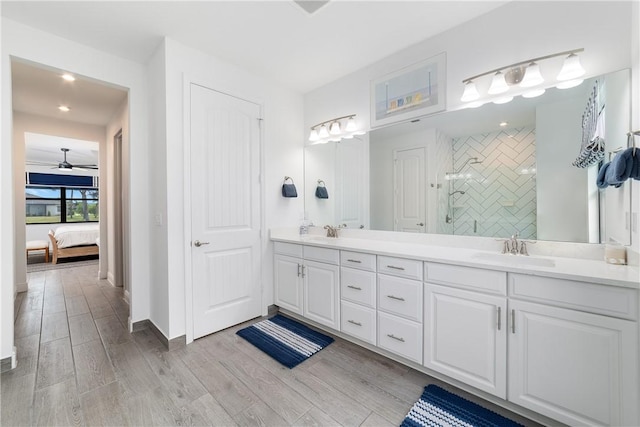 6354 Arcadia Sq, Vero Beach, FL 32966 - bathroom featuring double vanity, a tile shower, wood finished floors, connected bathroom, and recessed lighting