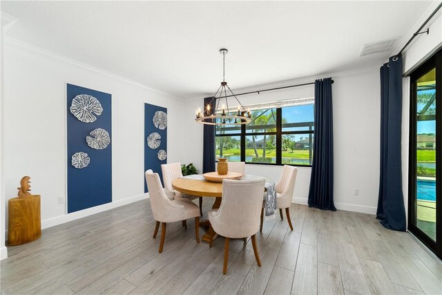 6354 Arcadia Sq, Vero Beach, FL 32966 - dining space with a chandelier, light wood finished floors, crown molding, and baseboards