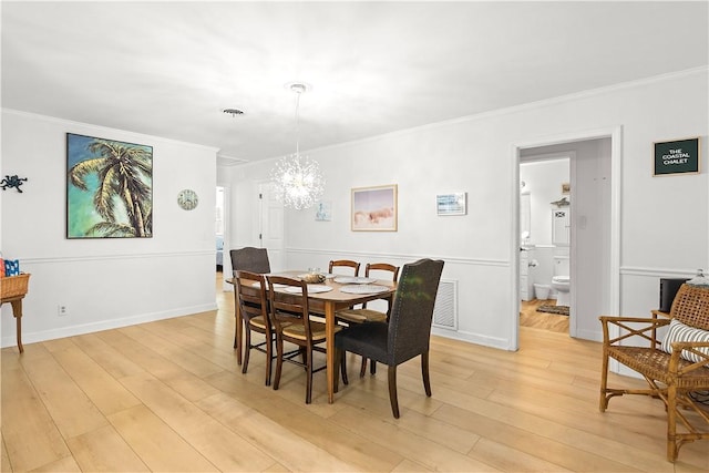 955 28th Ave, Vero Beach, FL 32960 - dining space featuring a chandelier, light wood-type flooring, crown molding, and baseboards