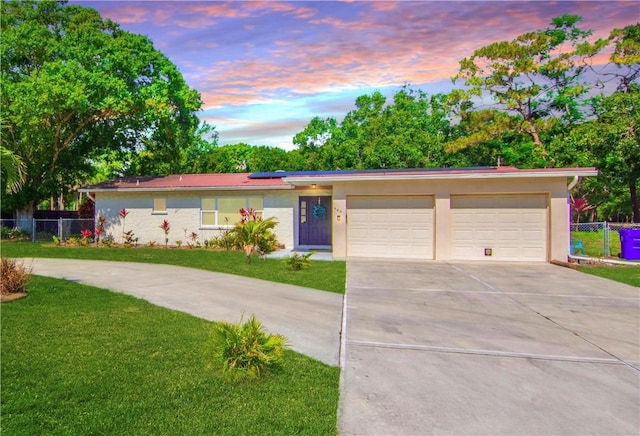 955 28th Ave, Vero Beach, FL 32960 - ranch-style house featuring driveway, roof mounted solar panels, an attached garage, and stucco siding