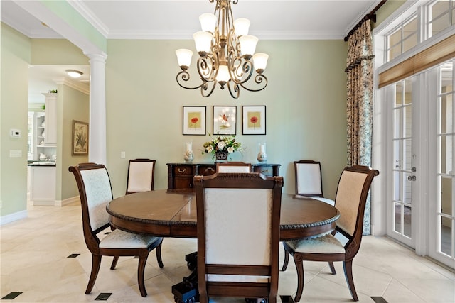 dining room featuring decorative columns, an inviting chandelier, and crown molding