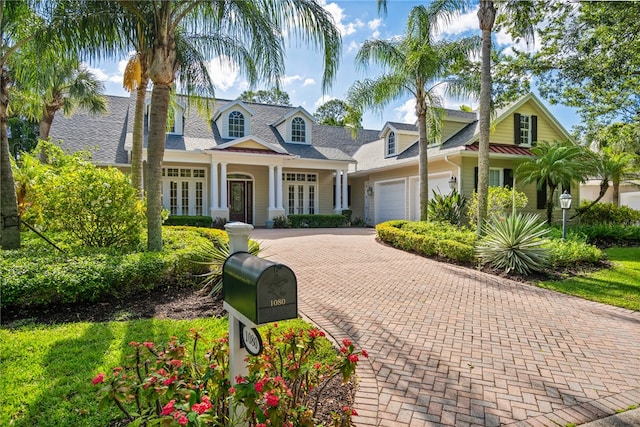 cape cod home with a garage and covered porch