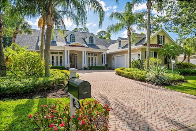1080 Carolina Cir SW, Vero Beach, FL 32962 - cape cod home featuring an attached garage, french doors, and decorative driveway