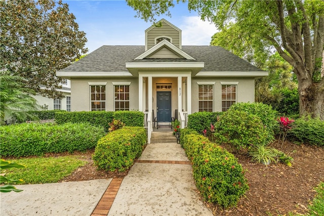 view of front of home with stucco siding and a shingled roof