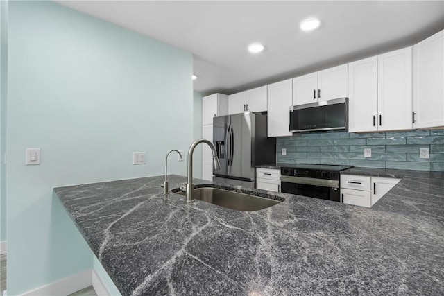 12 Plantation Dr Unit 104, Vero Beach, FL 32966 - kitchen featuring stainless steel appliances, a sink, tasteful backsplash, a peninsula, and white cabinets