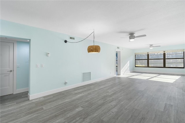 12 Plantation Dr Unit 104, Vero Beach, FL 32966 - unfurnished living room featuring wood finished floors, baseboards, and a ceiling fan