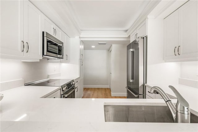 kitchen featuring sink, crown molding, light hardwood / wood-style flooring, appliances with stainless steel finishes, and white cabinetry