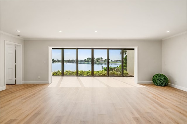 empty room with a water view, crown molding, and light hardwood / wood-style flooring