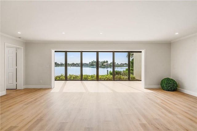 unfurnished room featuring light hardwood / wood-style floors, a water view, and ornamental molding