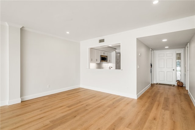 interior space with light wood-type flooring and ornamental molding