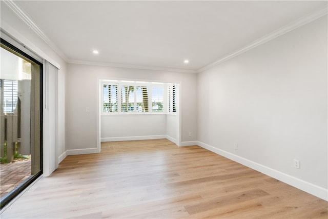 spare room featuring crown molding and light hardwood / wood-style floors