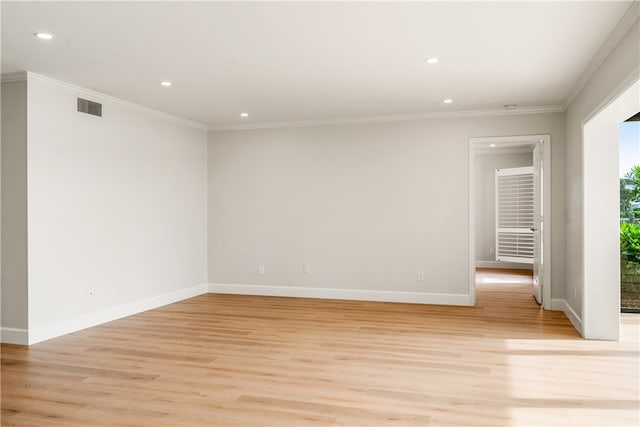 spare room featuring light hardwood / wood-style flooring and crown molding