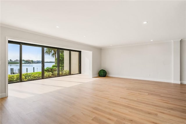 unfurnished room featuring crown molding, a water view, and light hardwood / wood-style floors