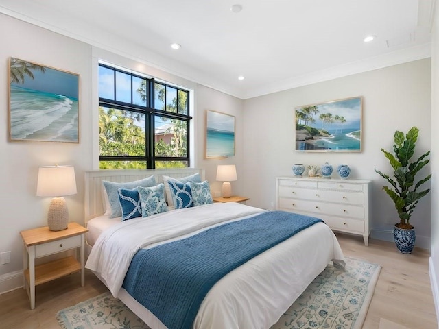 bedroom featuring ornamental molding and light hardwood / wood-style flooring