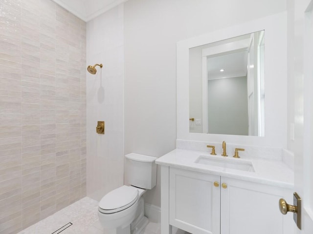 bathroom with toilet, tiled shower, and vanity