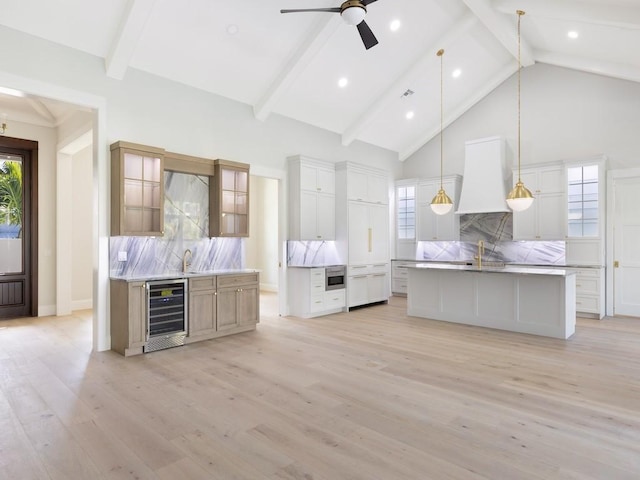 kitchen with a large island, white cabinetry, beverage cooler, and backsplash