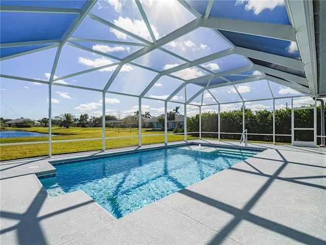 view of pool featuring a lawn, glass enclosure, and a patio area